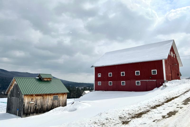 Red barn and farm buildings in a snowy Vermont landscape